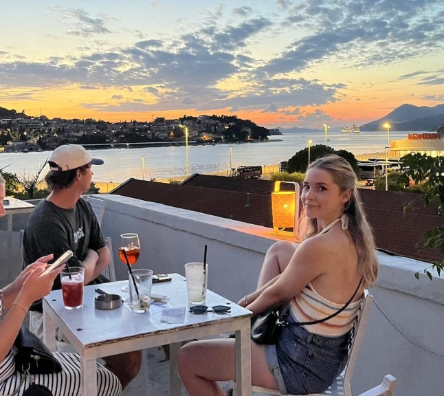 Man and woman sitting on sunset terrace looking at sunset