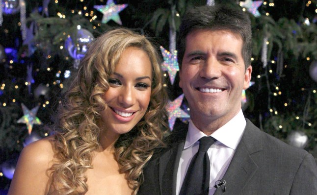 Leona Lewis smiling while posing with Simon Cowell after winning The X Factor in 2006