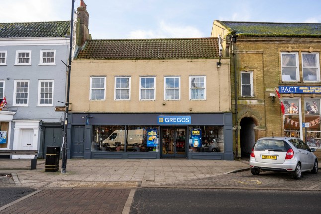 GV of Greggs in Swaffham, Norfolk. December 20, 2024. A posh market town has lost its battle to stop a Greggs' store opening on its high street. More than 1,000 residents in Swaffham, Norfolk, signed a petition and locals threatened a boycott after the chain submitted plans to move into a vacant unit. Townsfolk said big name businesses aren't welcome in the pretty high street amid fears it would kill of a popular family-run bakery. The new shop opened last month without planning permission, but locals still held out hope the local council would take enforcement action against the company. But town hall chiefs have granted the bakery giant the retrospective permission to stay open in a unit left vacant when a budget furniture store closed last year. While Greggs did not require planning permission for use of the former QD Furniture unit, the applications lodged with Breckland Council sought approval for an illuminated sign, a new air conditioning system and an outdoor seating area. It comes after Karl Chappell, a regular customer at Wellbread Bakers, launched a petition against the new Greggs store, attracting more than 1,000 signatures. Wellbread has been based in the town for several decades and loyal customers pledged to boycott the rival bakery if it opened in the town.